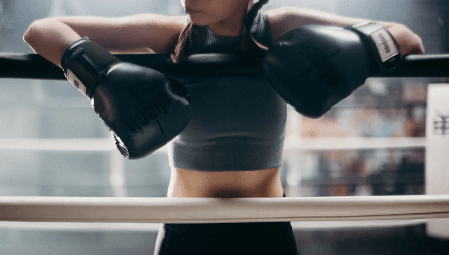 Une femme au bord du ring, avec ses gants